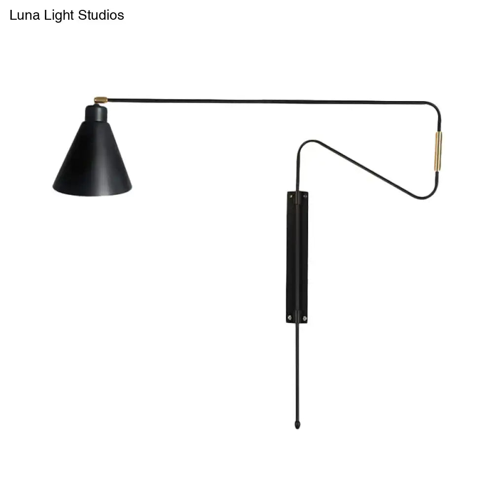 Modern black metal wall lamp with long articulated arm, black matte finish, and brass accents for living room use