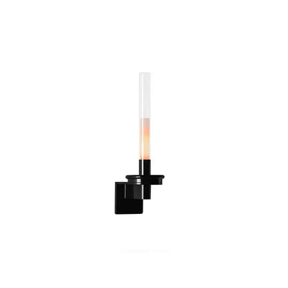 Modern black metal wall light featuring a clear glass cylindrical shade emitting warm light for bedroom use