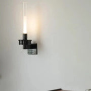 Modern black metal wall light with clear glass shade and sleek design suitable for bedroom wall light