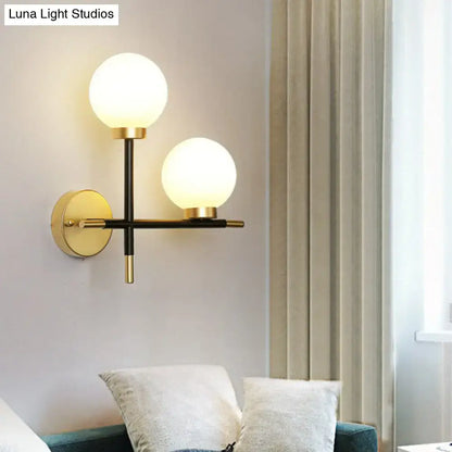 Modern black wall mount light fixture with milk glass globes and brass accents two-light sconce for foyer