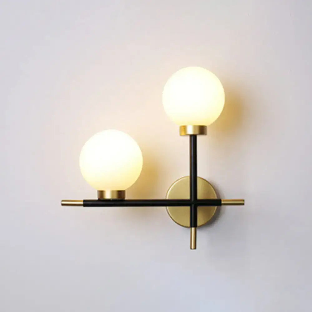 Modern black two-light wall mount light fixture with frosted milk glass globe shades for foyer use