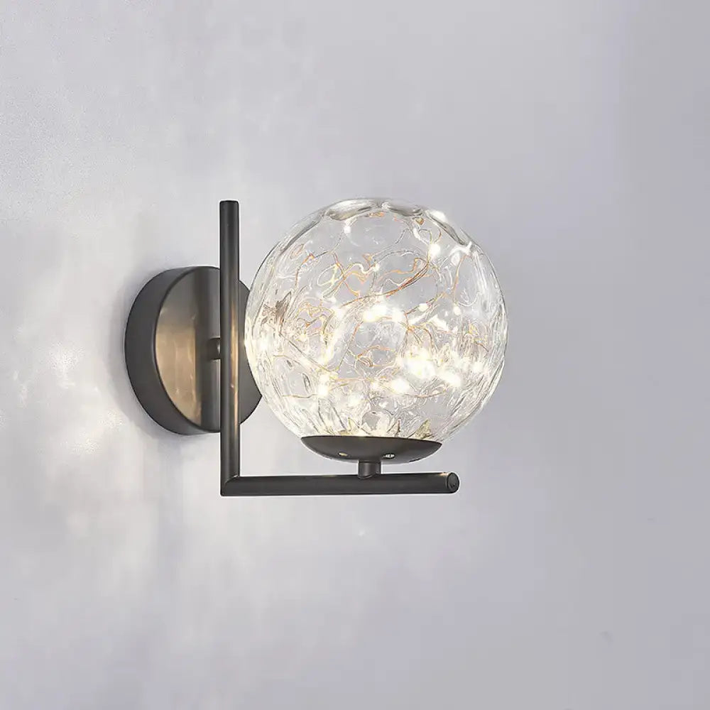 Modern black mini globe wall sconce with textured clear glass and delicate led lights on a sleek metal frame fixture height