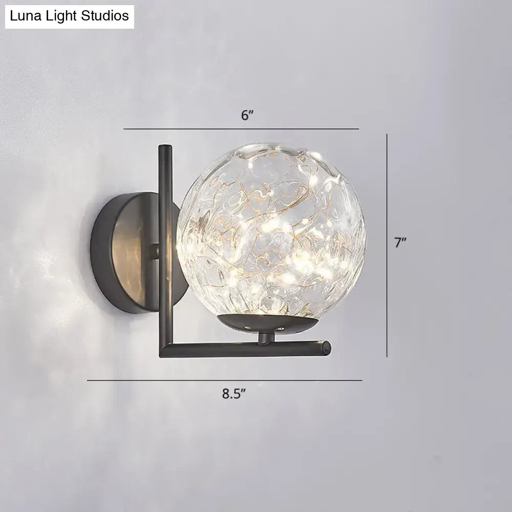 Modern black mini globe wall sconce with a textured clear glass globe and sleek metal bracket featuring delicate led lights