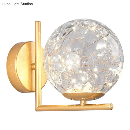 Gold-finished mini globe wall sconce with textured clear glass globe and fairy lights fixture height suitable for bedrooms