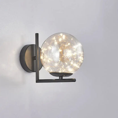 Modern black mini globe wall sconce with spherical glass globe and fairy lights showcasing fixture height in bedroom use