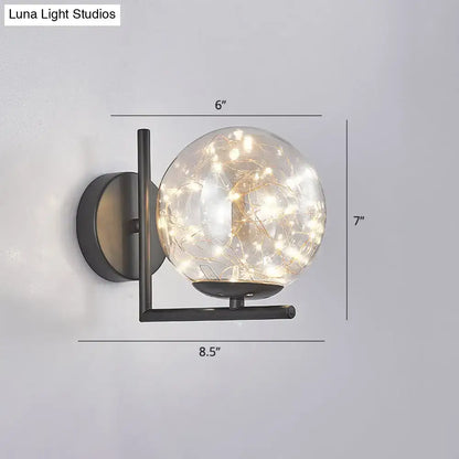 Modern black mini globe wall sconce with clear glass globe housing warm fairy lights and compact fixture height