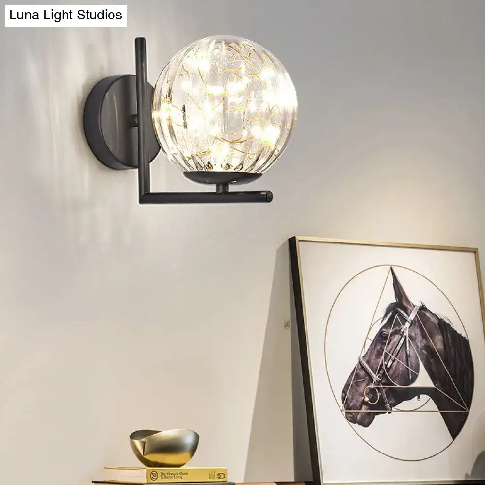 Modern black metal mini globe wall sconce with gold filigree spherical glass and glowing led lights fixture height shown