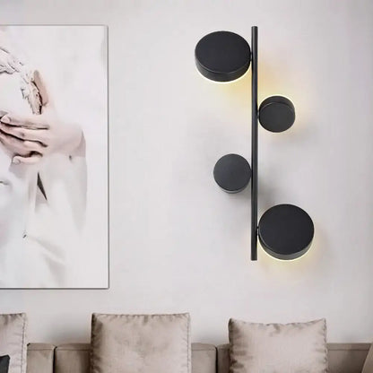 Modern black minimalist circle wall mount led sconce with sleek vertical rod providing warm ambient living room lighting