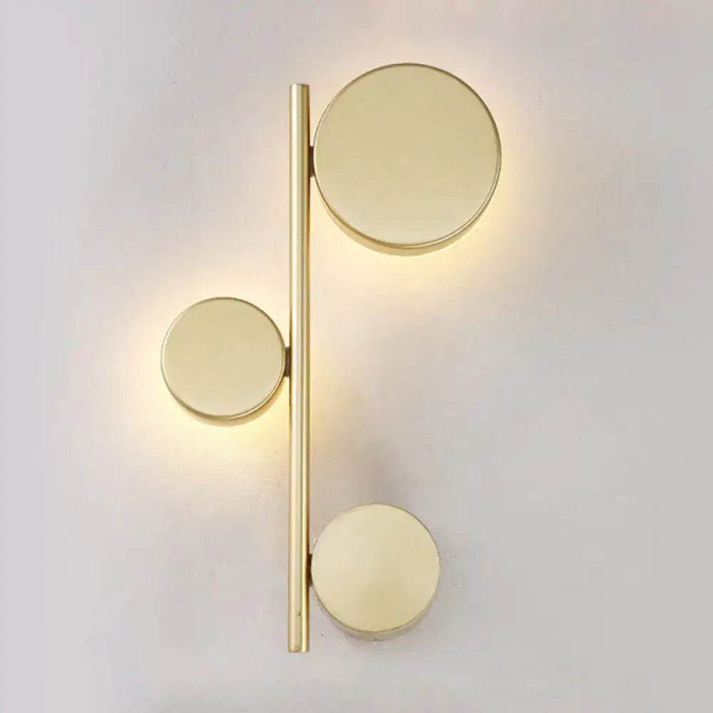 Gold-toned minimalist circle wall mount sconce with three discs on slender rod for living room lighting