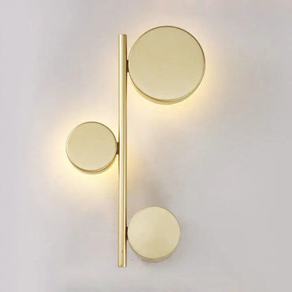 Gold-toned minimalist circle wall mount sconce with three discs on slender rod for living room lighting