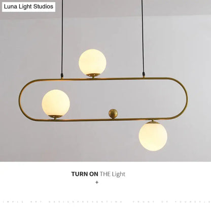 Modern brass pendant ceiling light with three frosted glass globes and black cords for minimalist ellipse living room decor