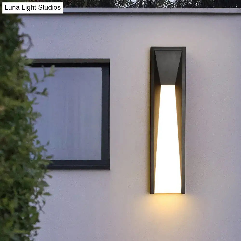 Modern black minimalist led wall light with sleek angular design emitting warm white light for courtyard use