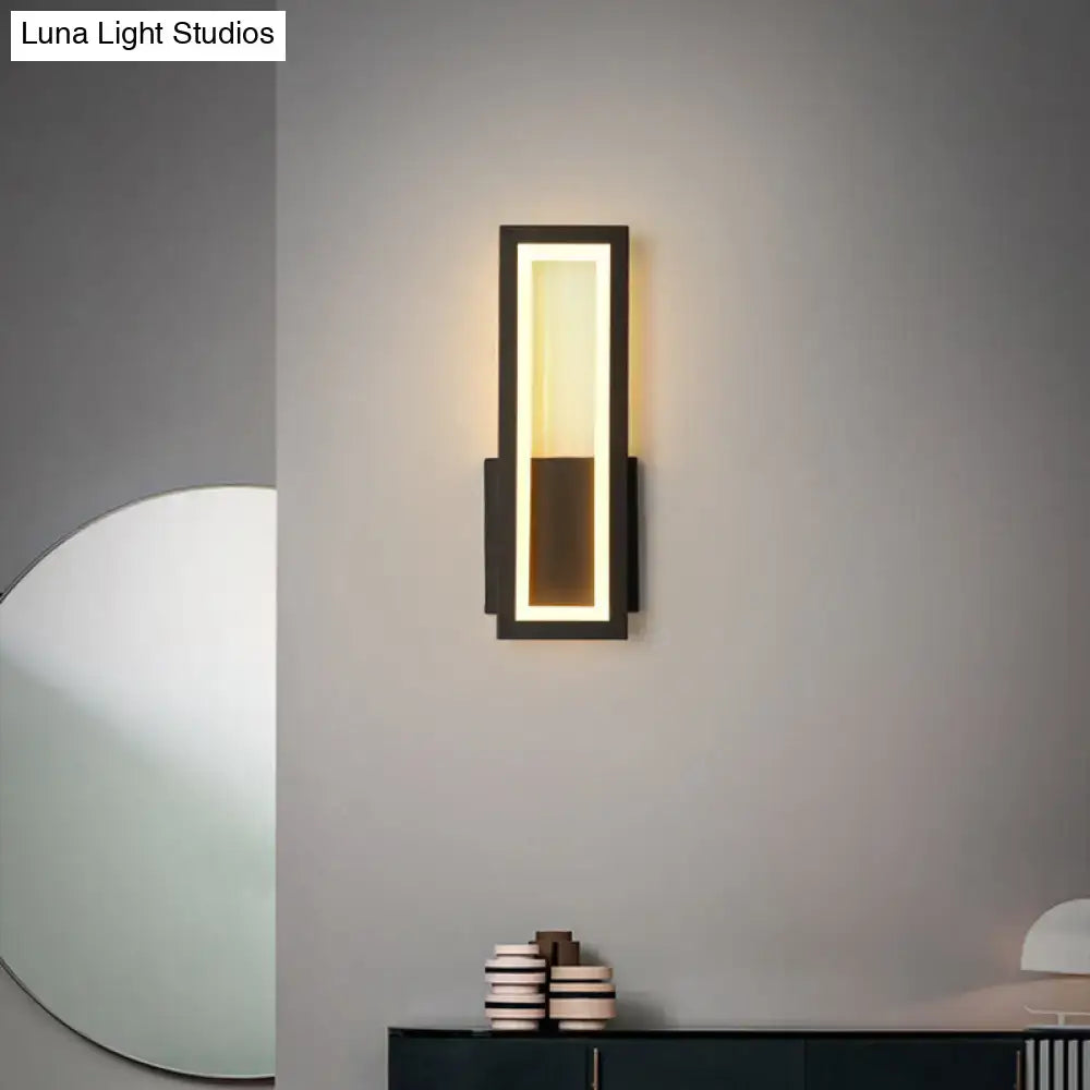 Modern black minimalist wall sconce with sleek rectangular design and warm LED lighting for foyer use