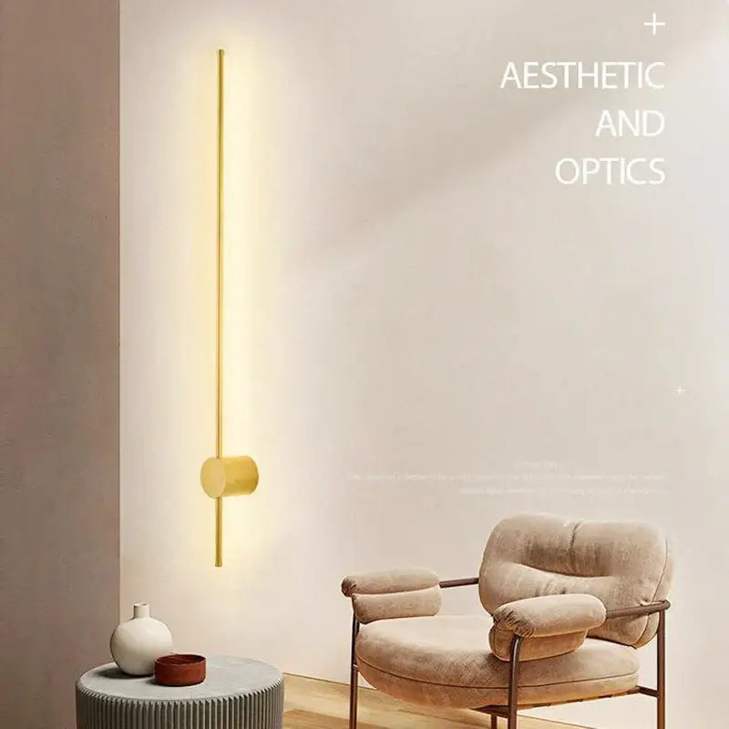 Gold-toned minimalist rotatable led wall sconce with sleek vertical bar and cylindrical base emitting warm ambient light