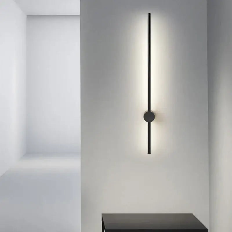 Modern black minimalist rotatable led wall light with sleek vertical rod and circular base emitting soft ambient light