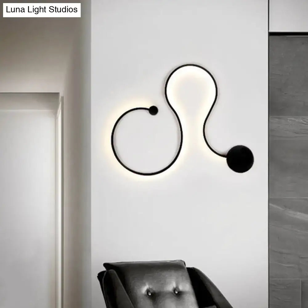 Modern black minimalist wall lamp with sleek curved design and glowing white light wall lamp for living room use