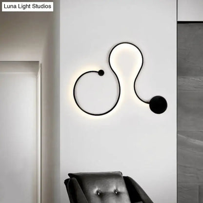 Modern black minimalist wall lamp with sleek curved design and glowing white light wall lamp for living room use