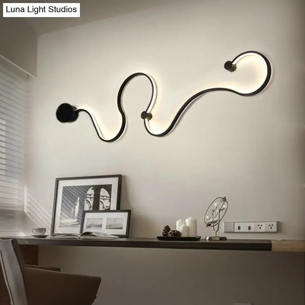 Modern black minimalist wall lamp with sleek curved design emitting white light for living room use