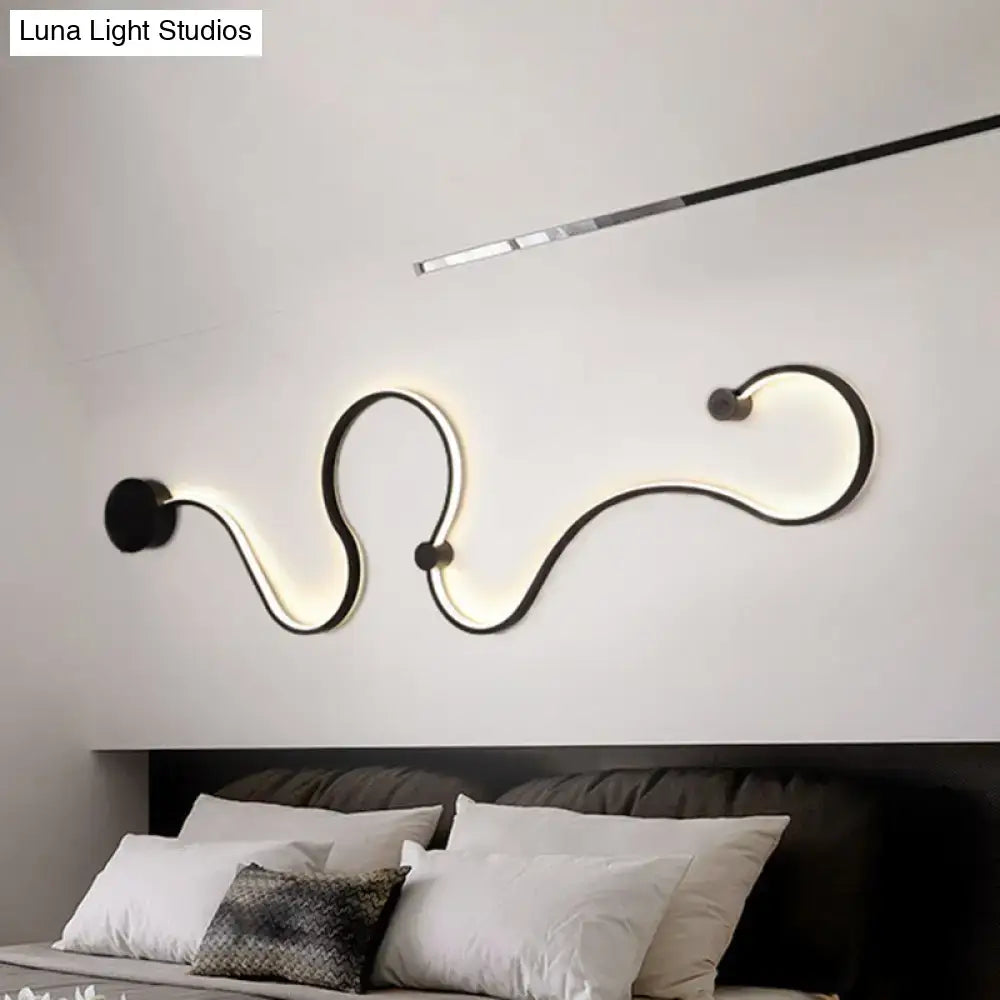 Modern black minimalist wall lamp with sleek curved design and glowing white light for living room use