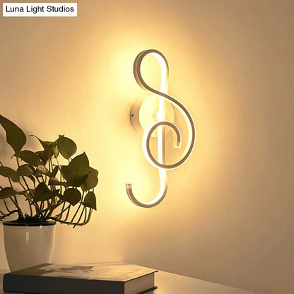 Modern black wall light with music note design featuring an illuminated led treble clef and minimalist metallic finish