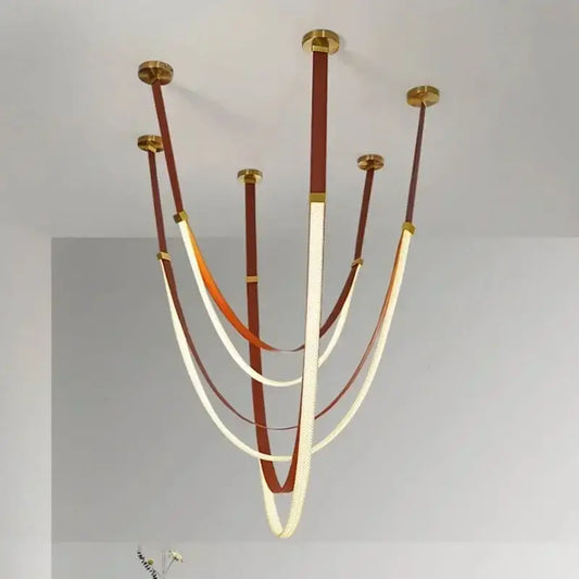 Modern pendant light with gold metal fixtures and brown and cream leather straps for modern interiors color options