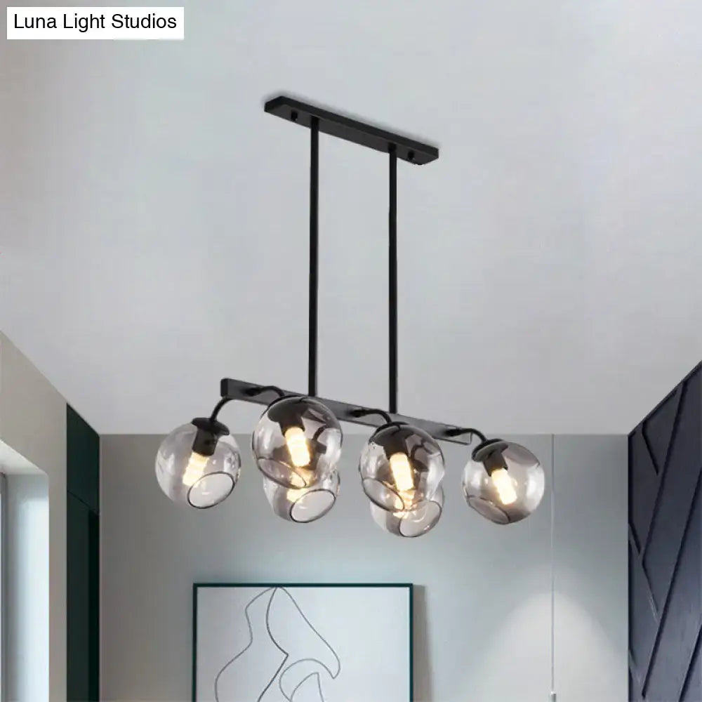 Modern black metal chandelier with four clear glass globe shades featuring black orb shade for kitchen and dining room