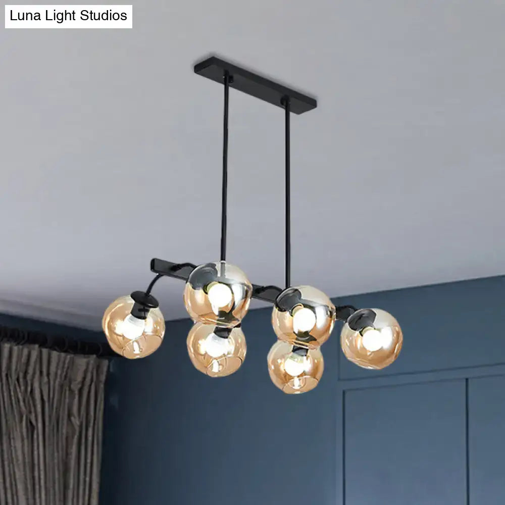 Modern black metal chandelier with five reflective gold glass globe bulbs and black orb shade for kitchen and dining room