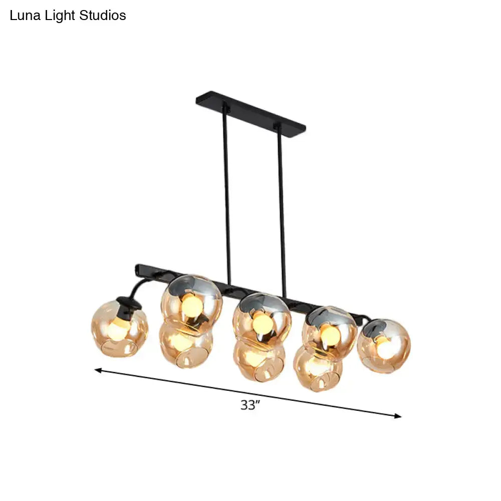 Black metal chandelier with five amber glass globe lights and orb shade for kitchen and dining room by DecorBites