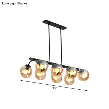 Black metal chandelier with five amber glass globe lights and orb shade for kitchen and dining room by DecorBites