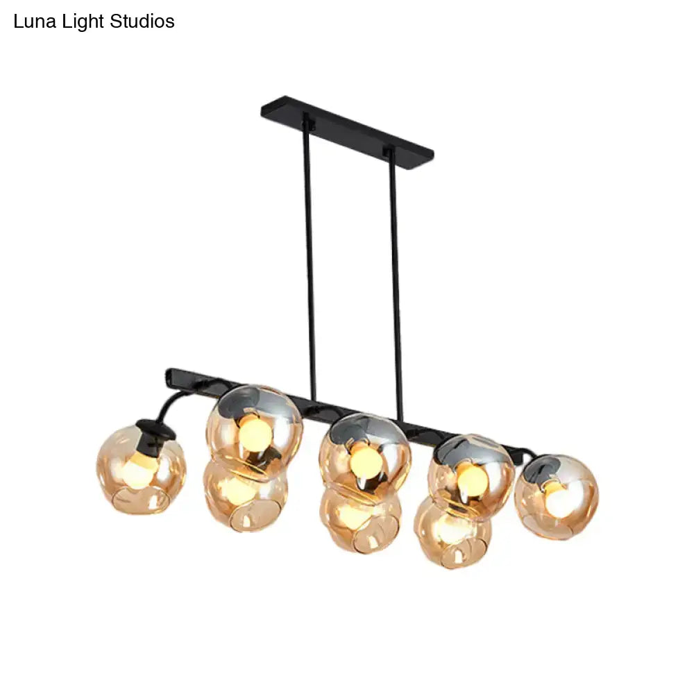 Modern black metal chandelier with five amber glass globe shades featuring orb shade design for kitchen and dining room