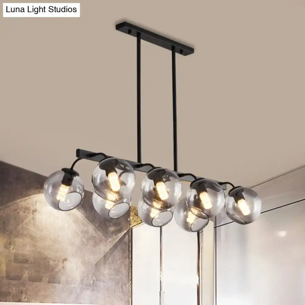 Modern black metal chandelier with five clear glass globe shades featuring a black orb shade for kitchen and dining room