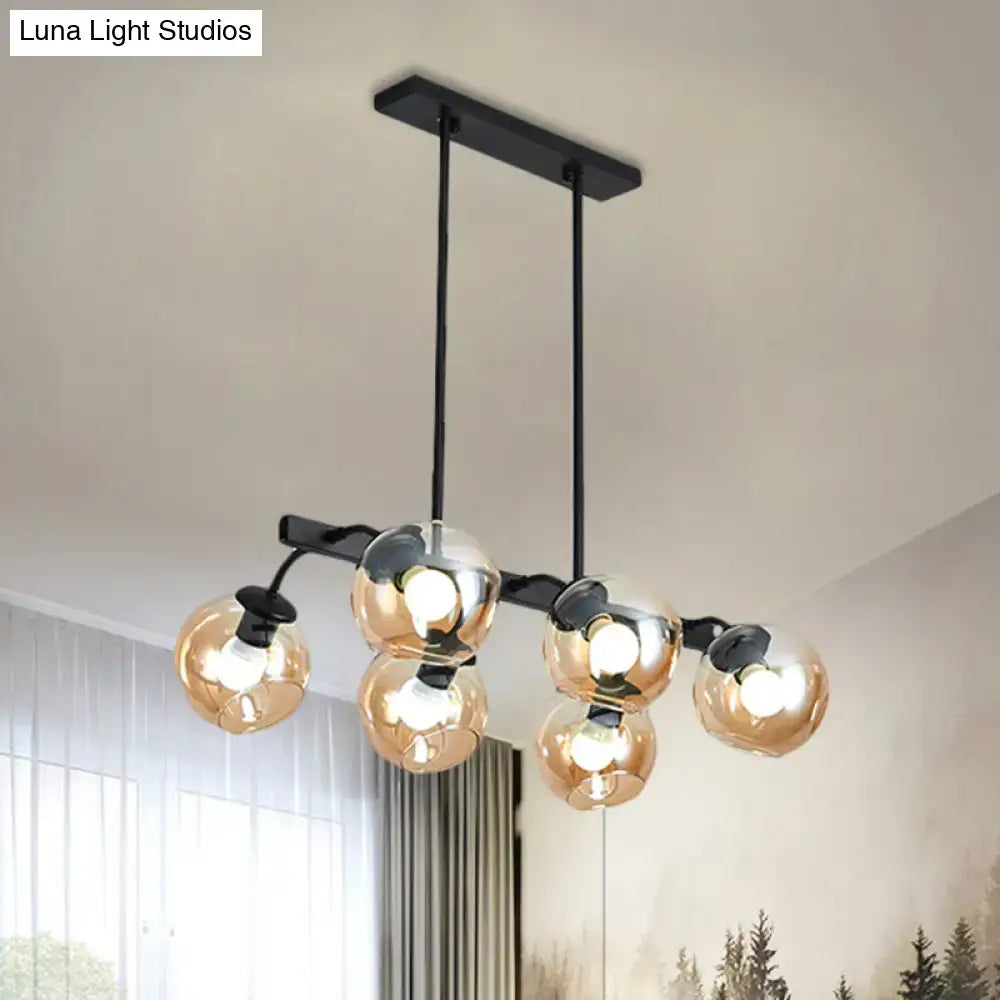Modern black metal chandelier with five amber-tinted glass globe bulbs and orb shade for kitchen and dining room use