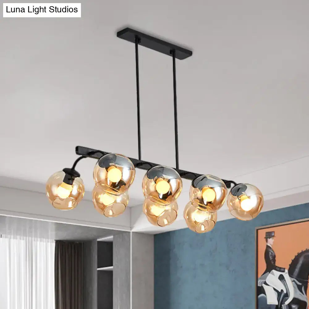 Modern black metal chandelier with five spherical amber glass globe shades featuring orb shade for kitchen and dining room
