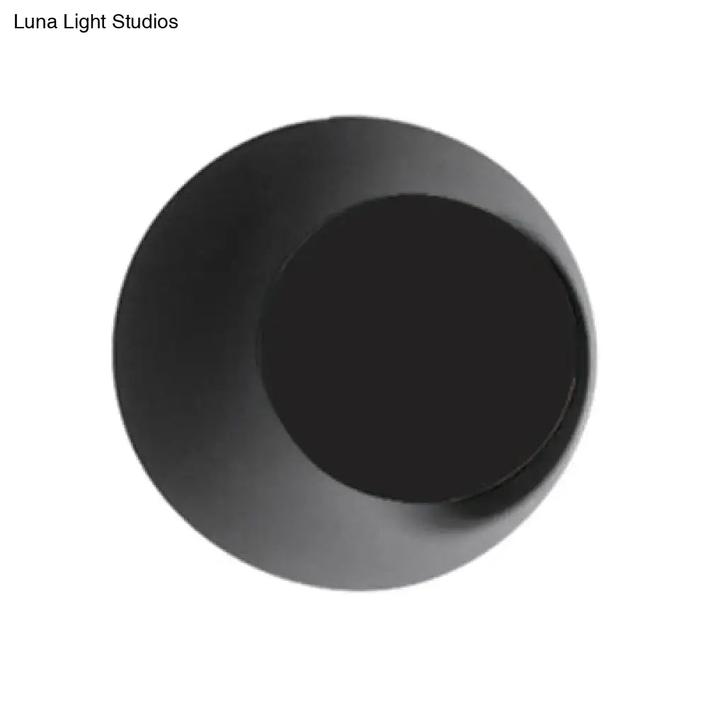 Modern black and pink circle sconce light fixture with a black matte concave center for bedroom wall lighting
