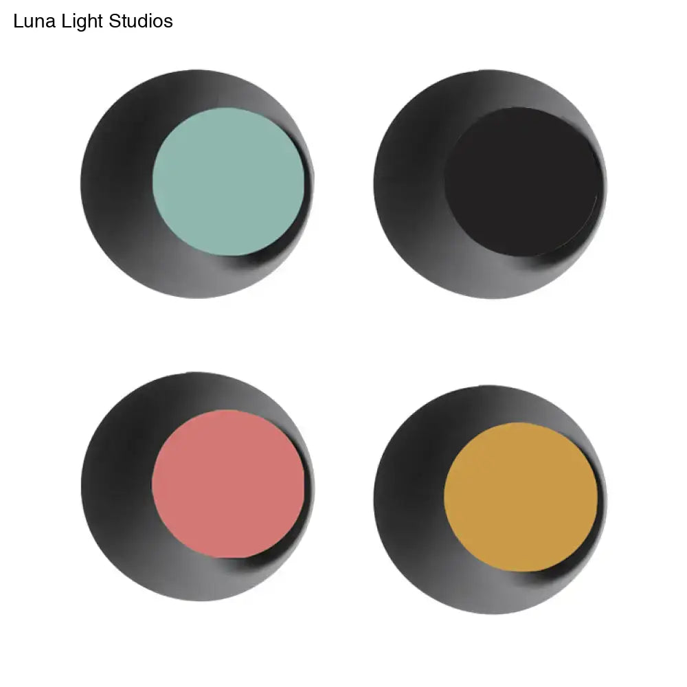 Set of four circular eyeshadow pans in matte black casing with teal black rose and mustard powders for makeup use