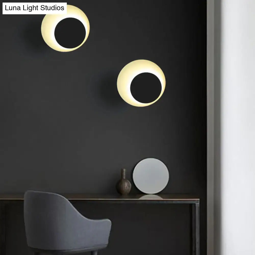 Modern black and pink circle sconce light fixture with warm glow and sleek black centers for bedroom wall lighting