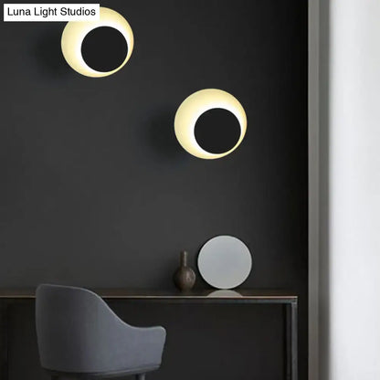 Modern black and pink circle sconce light fixture with warm glow and sleek black centers for bedroom wall lighting