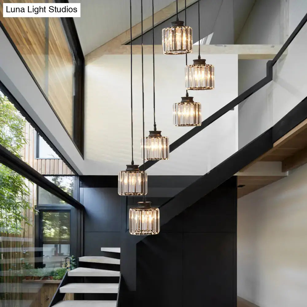 Five prismatic crystal cylindrical pendant lights with black metal fixtures and warm bulbs for stairway lighting