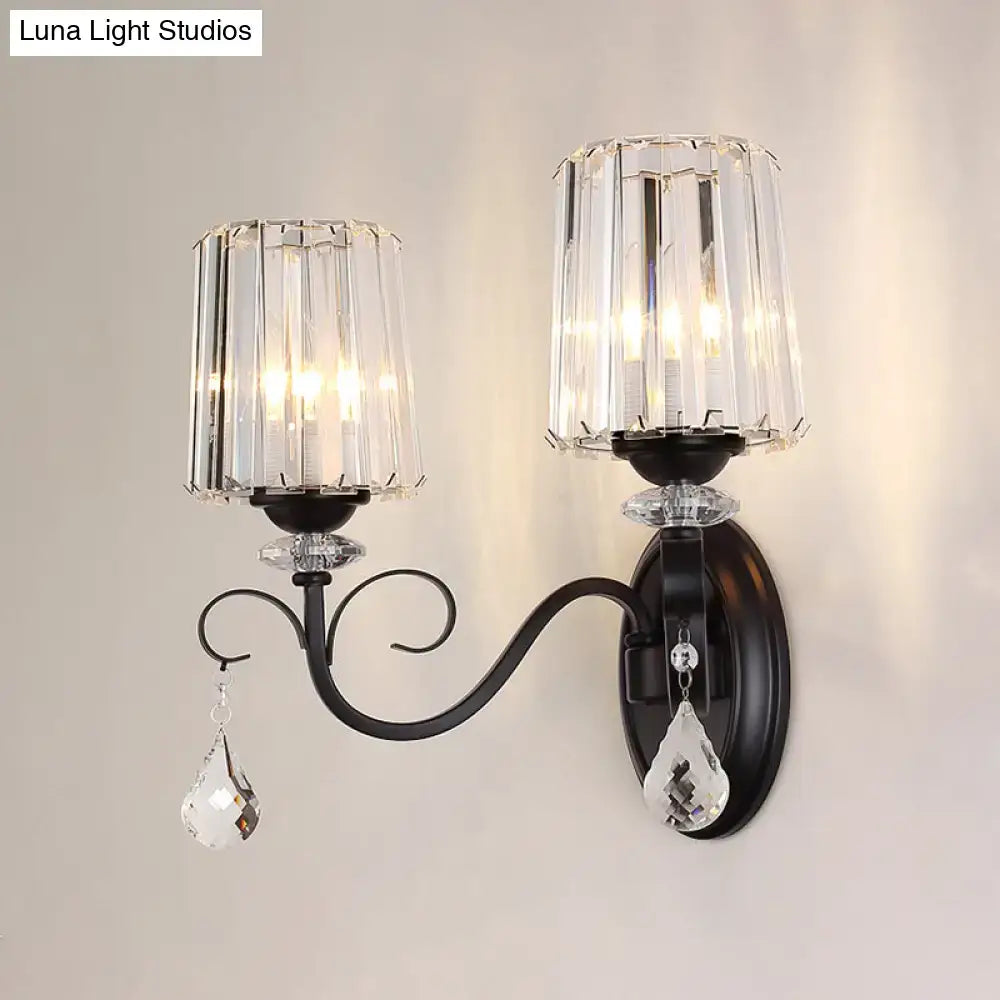 Elegant black wrought iron wall mount lamp with two crystal candle-style shades and dangling teardrop crystals for living room