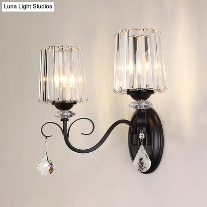Elegant black wrought iron wall mount lamp with two crystal candle-style shades and dangling teardrop crystals for living room