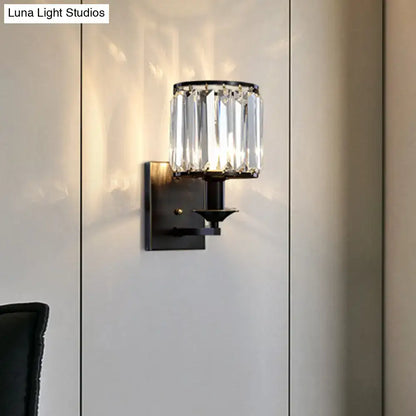 Modern black metal wall sconce with cylindrical prismatic crystal shade and e12 light type bulb base for bedroom use
