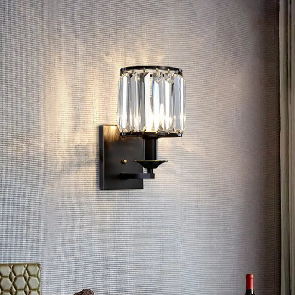 Modern black metal wall sconce with cylindrical prismatic crystal shade and e12 light type bulb base for bedroom use