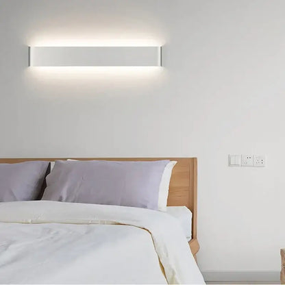 Modern black rectangular led wall lamp with sleek white minimalist design and subtle metallic edges for warm bedroom glow