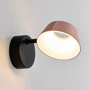 Modern black and rose gold sconce light with matte black base and rose gold shade emitting warm light, direct wired