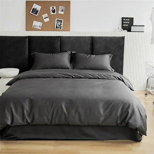 Modern black satin jacquard duvet cover set with matching pillows and bed skirt on black upholstered headboard