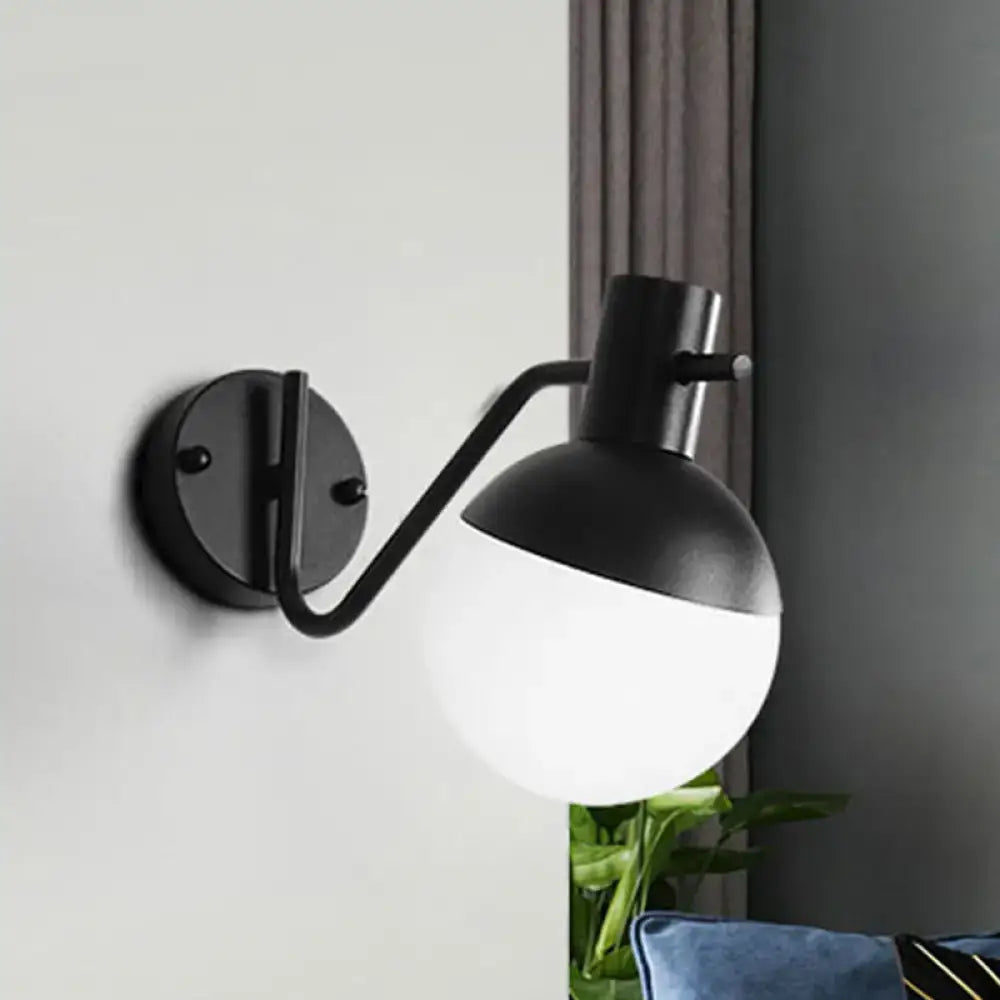 Modern black sconce light with black matte finish curved arm and spherical global milk glass shade for living room