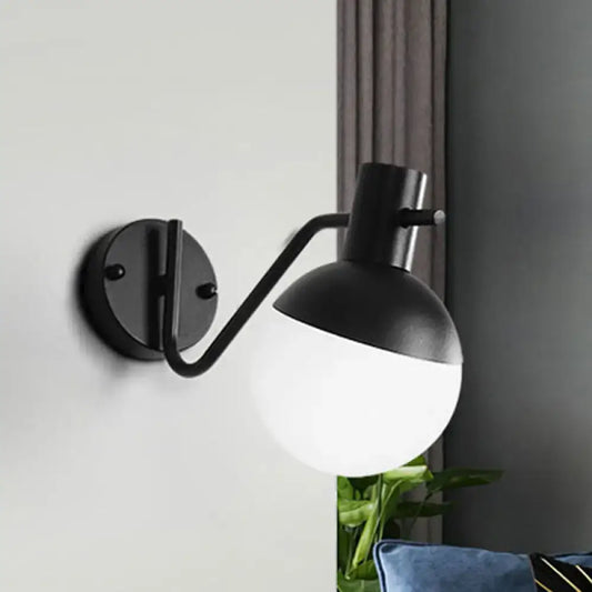 Modern black sconce light with black matte finish curved arm and spherical global milk glass shade for living room