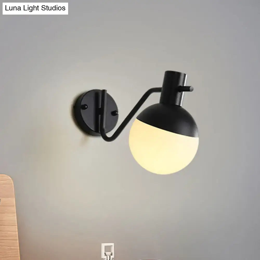 Modern black sconce light with matte black metal and warm glowing global milk glass shade for living room