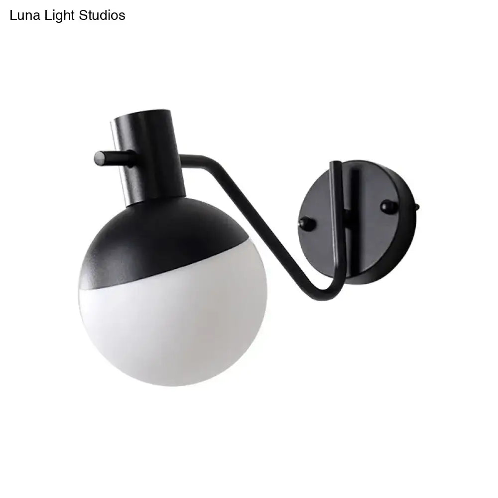 Modern black sconce light with a matte black metal frame and global milk glass shade for living room use