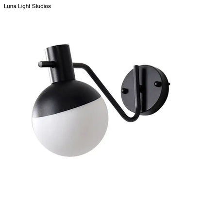 Modern black sconce light with a matte black metal frame and global milk glass shade for living room use